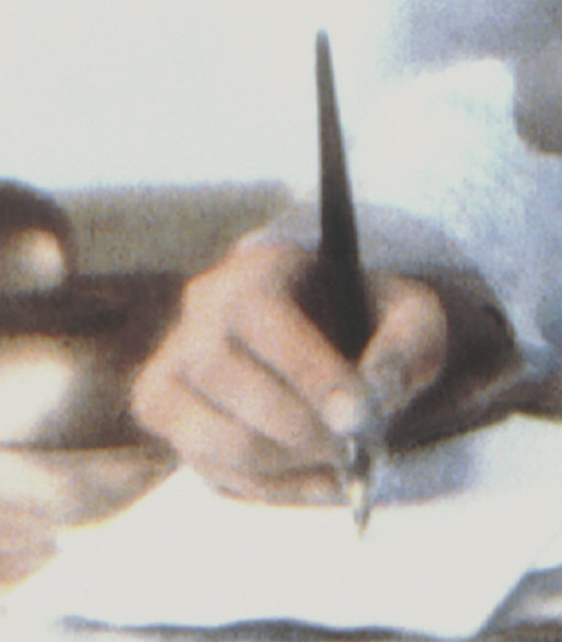 lose-up of Montgomery’s hand holding a wooden pen, inkwell to the left