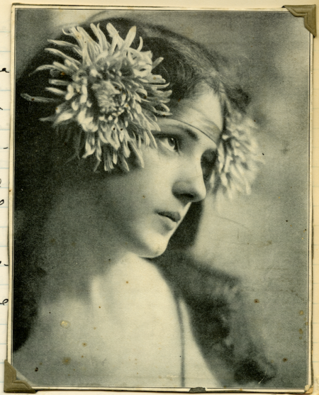 a photo of a woman in profile pasted with two large flowers on her headband
